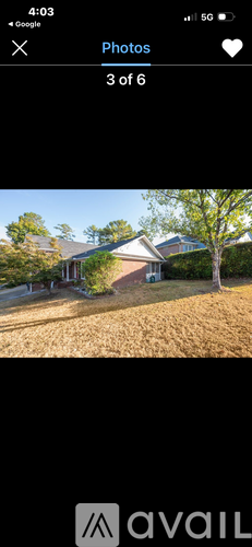 A house with a brown roof and a tree in front of it.