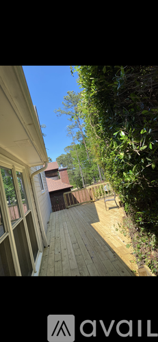 A balcony with a view of a house and trees.