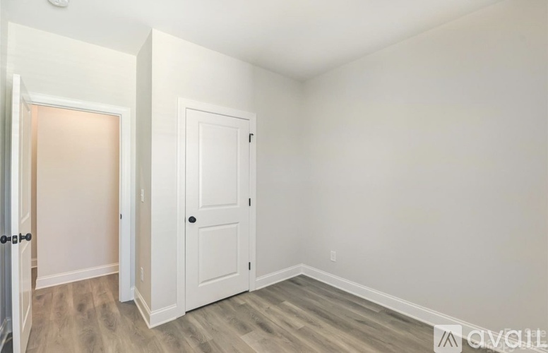 A room with a white door and a white wall.