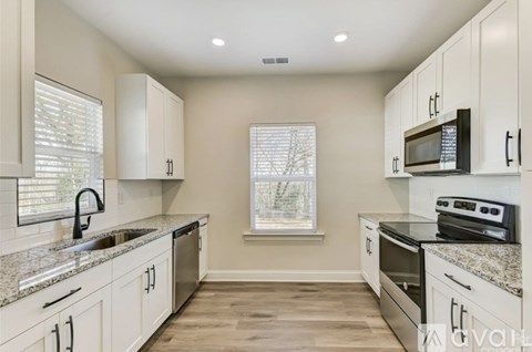 A kitchen with white cabinets and granite countertops.