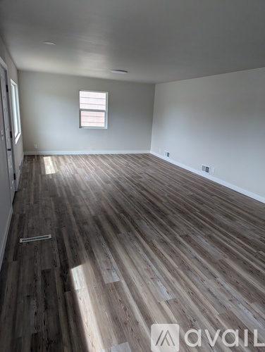 A room with wooden flooring and a window.
