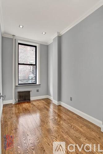 A room with wooden flooring and a window.