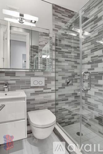 A white toilet sits in a bathroom with a glass shower stall.