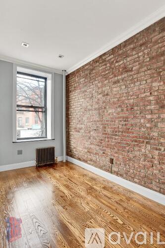A room with a brick wall and wooden floor.