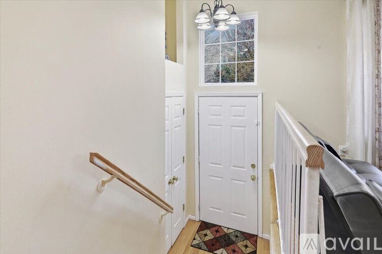 A white door is in a hallway with a window above it.