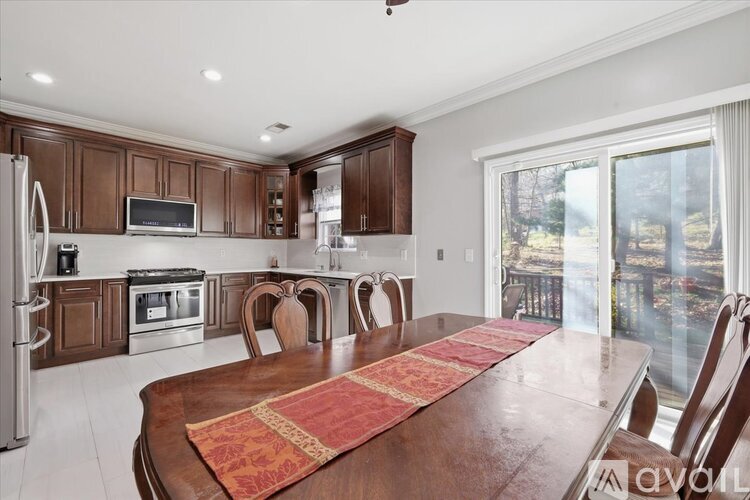 A kitchen with a table and chairs in front of a window.