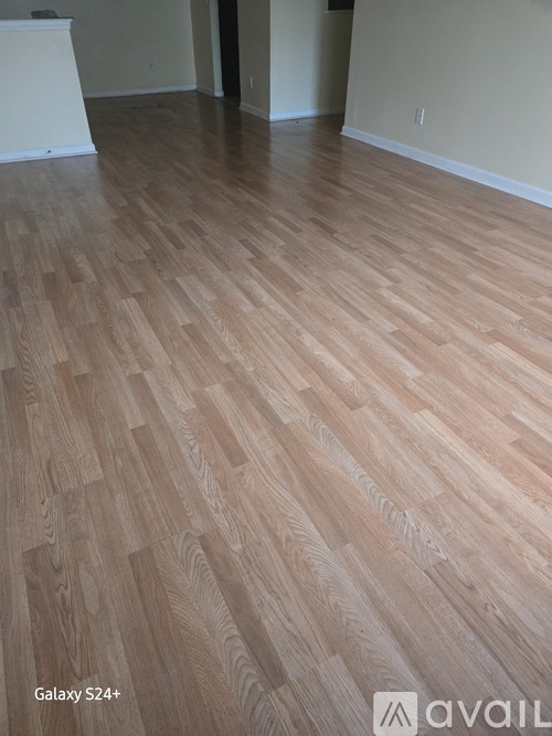 A room with wooden flooring and a white wall.