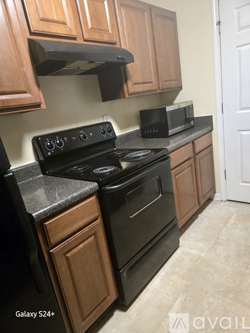 A kitchen with a black stove top oven and microwave.