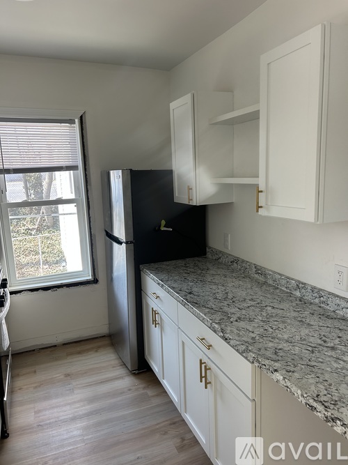 A kitchen with a granite countertop and white cabinets.