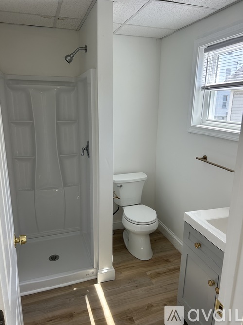A white toilet sits in a bathroom next to a shower.