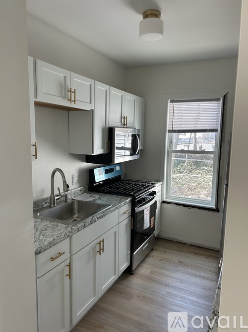 A kitchen with white cabinets and a granite countertop.