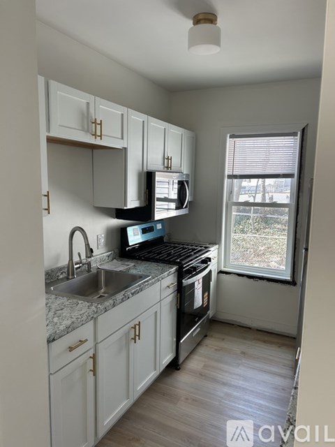 A kitchen with white cabinets and a granite countertop.