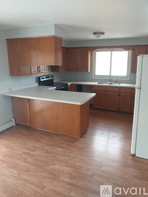 A kitchen with wooden cabinets and a white refrigerator.