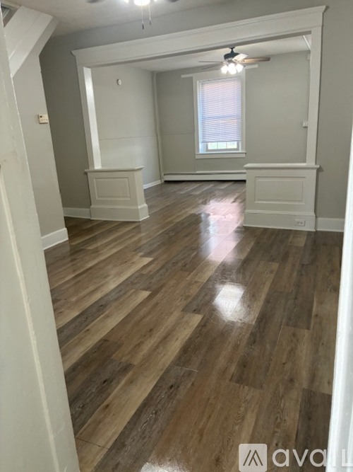 A room with wooden flooring and white walls.
