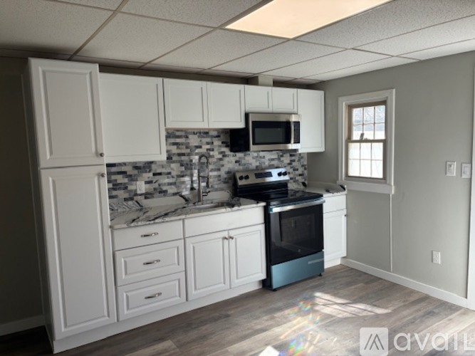 A kitchen with white cabinets and a black stove top oven.