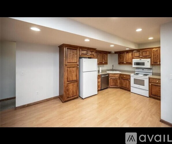 A kitchen with wooden cabinets and white appliances.