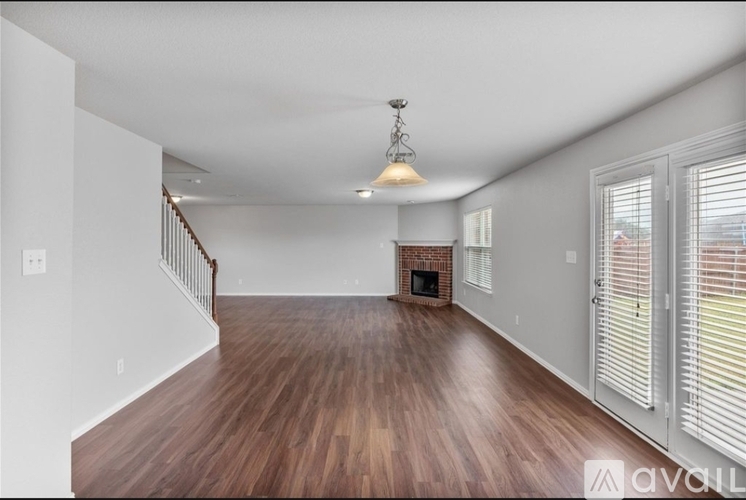 A living room with wood floors and a fireplace.