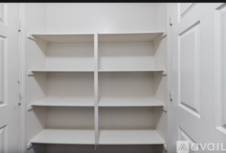 Empty white shelves in a white cabinet.