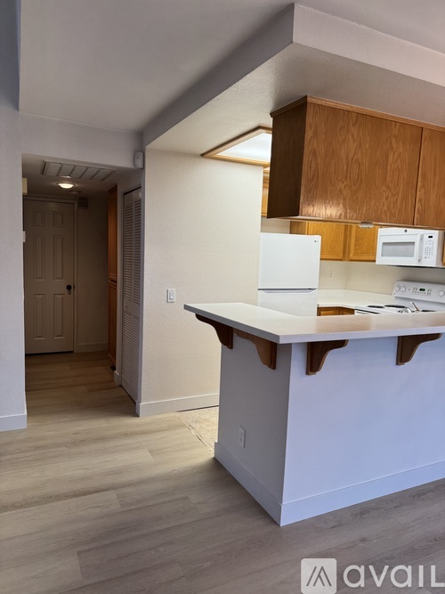 A kitchen with white appliances and wooden cabinets.