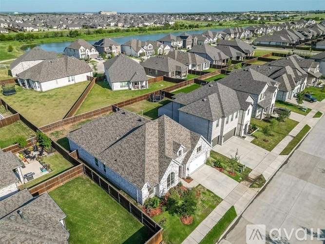 A bird's eye view of a suburban neighborhood with houses and a river in the distance.