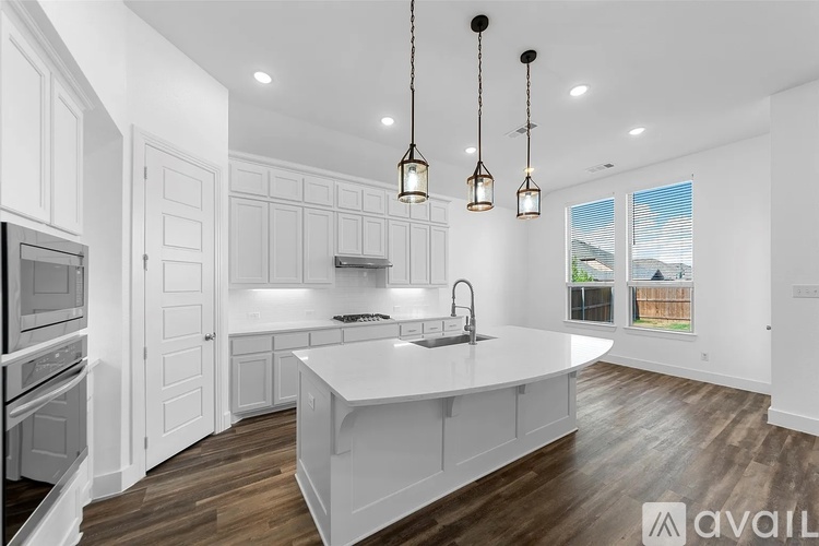 A modern kitchen with white cabinets and a large island.