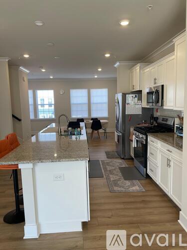 A kitchen with white cabinets and a granite countertop.