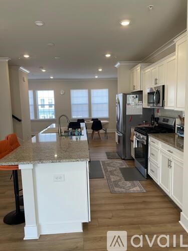 A kitchen with white cabinets and a granite countertop.