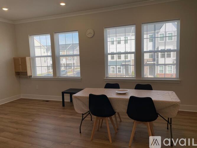 A dining room with a table and chairs.