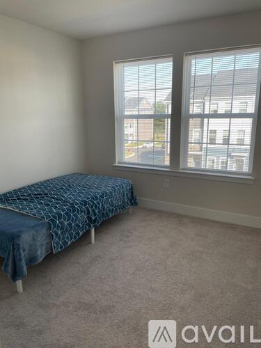 A bedroom with a bed and a window overlooking a street.