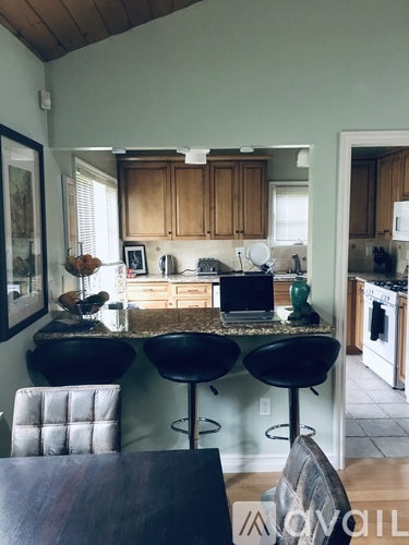 A kitchen with wooden cabinets and black stools.