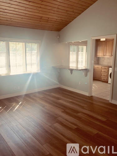 A room with wooden flooring and a window.