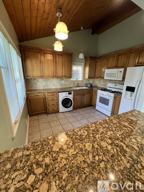 A kitchen with granite countertops and wooden cabinets.