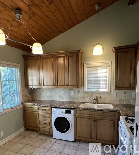A kitchen with wooden cabinets and a washing machine.