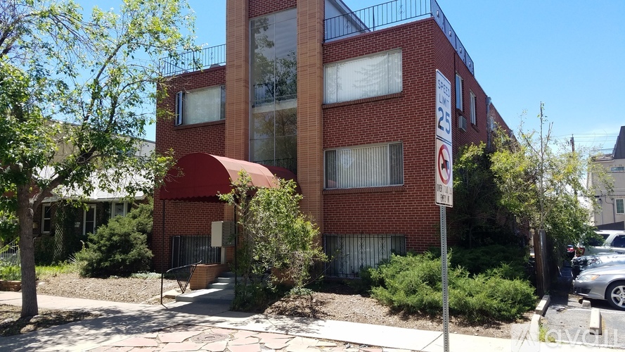 A red building with a no parking sign in front of it.