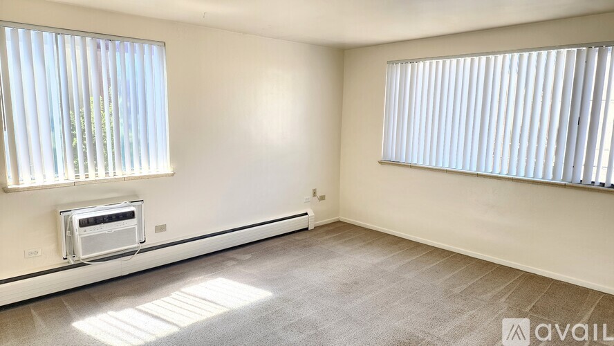 A room with a window and a microwave oven built into the wall.