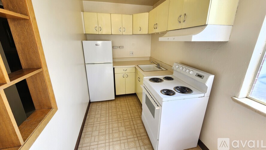 A kitchen with a white fridge, white oven, and brown cabinets.