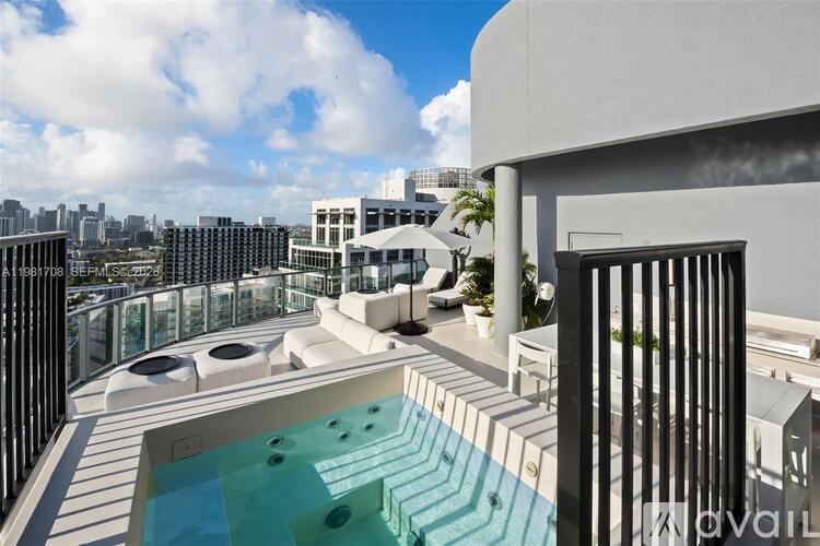 A modern balcony with a pool and city view.