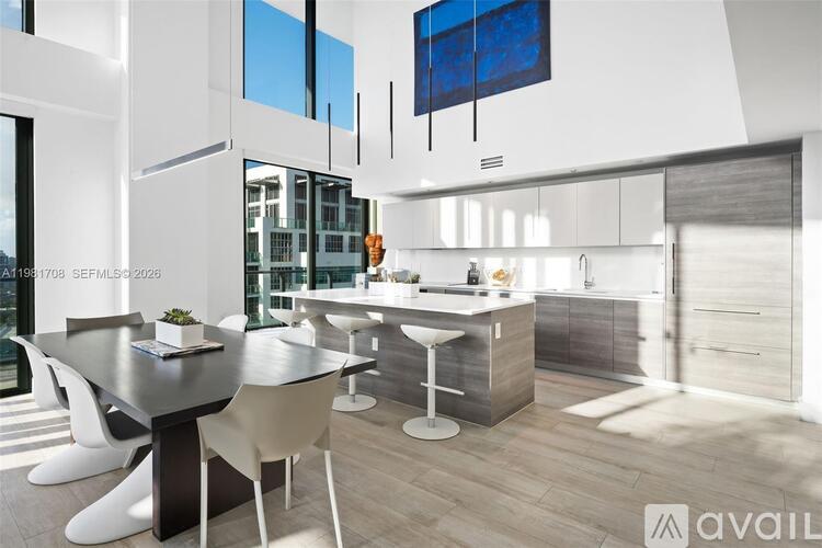 A modern kitchen with a dining table and chairs.