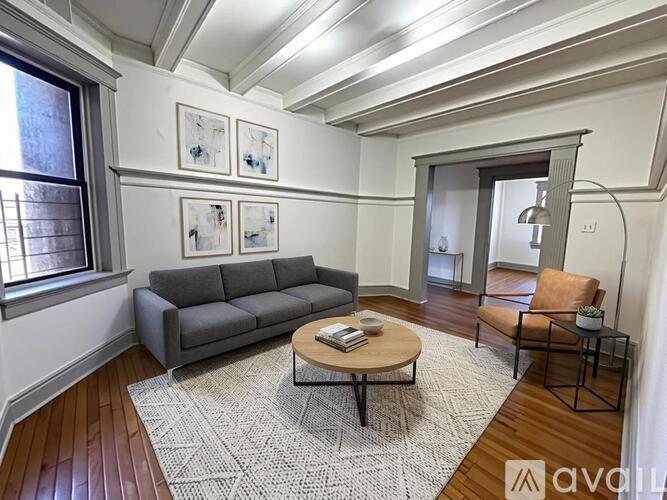 A living room with a grey couch, a coffee table, and a rug.