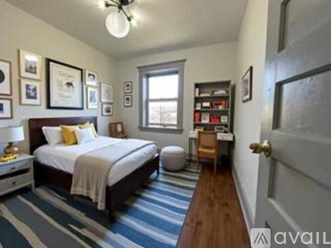 A bedroom with a bed, a desk, and a chair.
