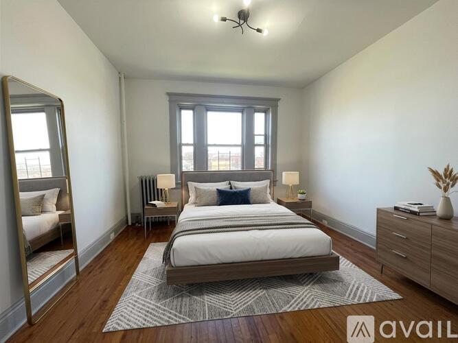 A bedroom with a bed, dresser, and mirror.