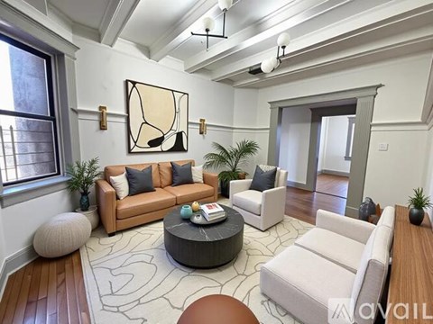 A living room with a large abstract painting on the wall, a sofa set, a coffee table, and a rug.