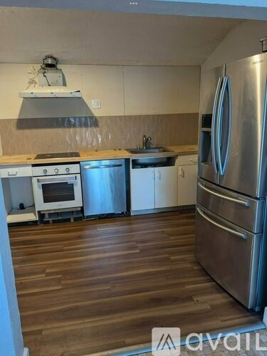 A kitchen with a stainless steel refrigerator, oven, and microwave.