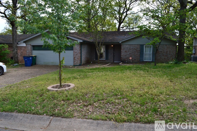 A house with a tree in the front yard.