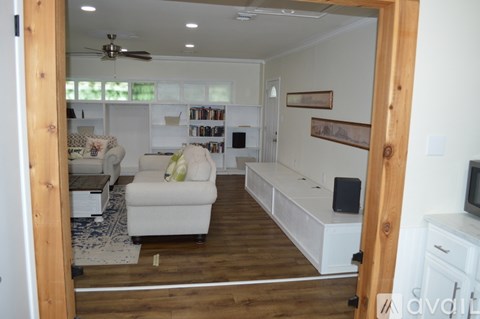 A living room with a white couch and a wooden floor.