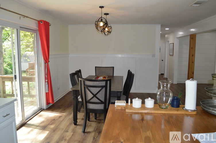A dining room with a wooden table and chairs.