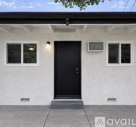 A white house with a black door and windows.