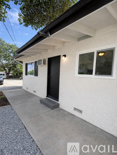 A white house with a black door and windows.