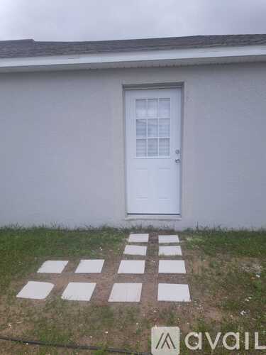 A white door with a glass window is on a white house.