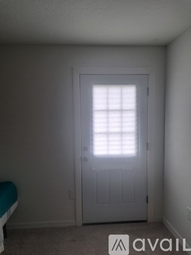 A white door with a window above it in a room.